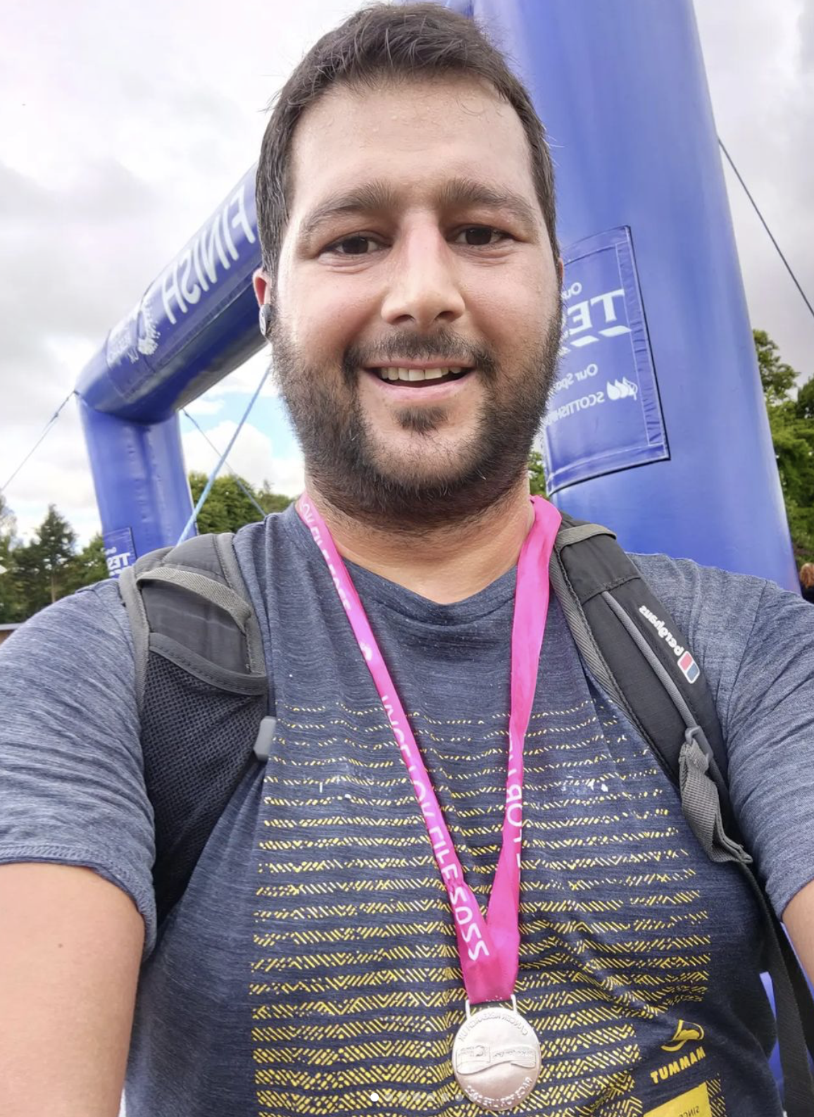 Me standing wearing a Race for Life 10km medal