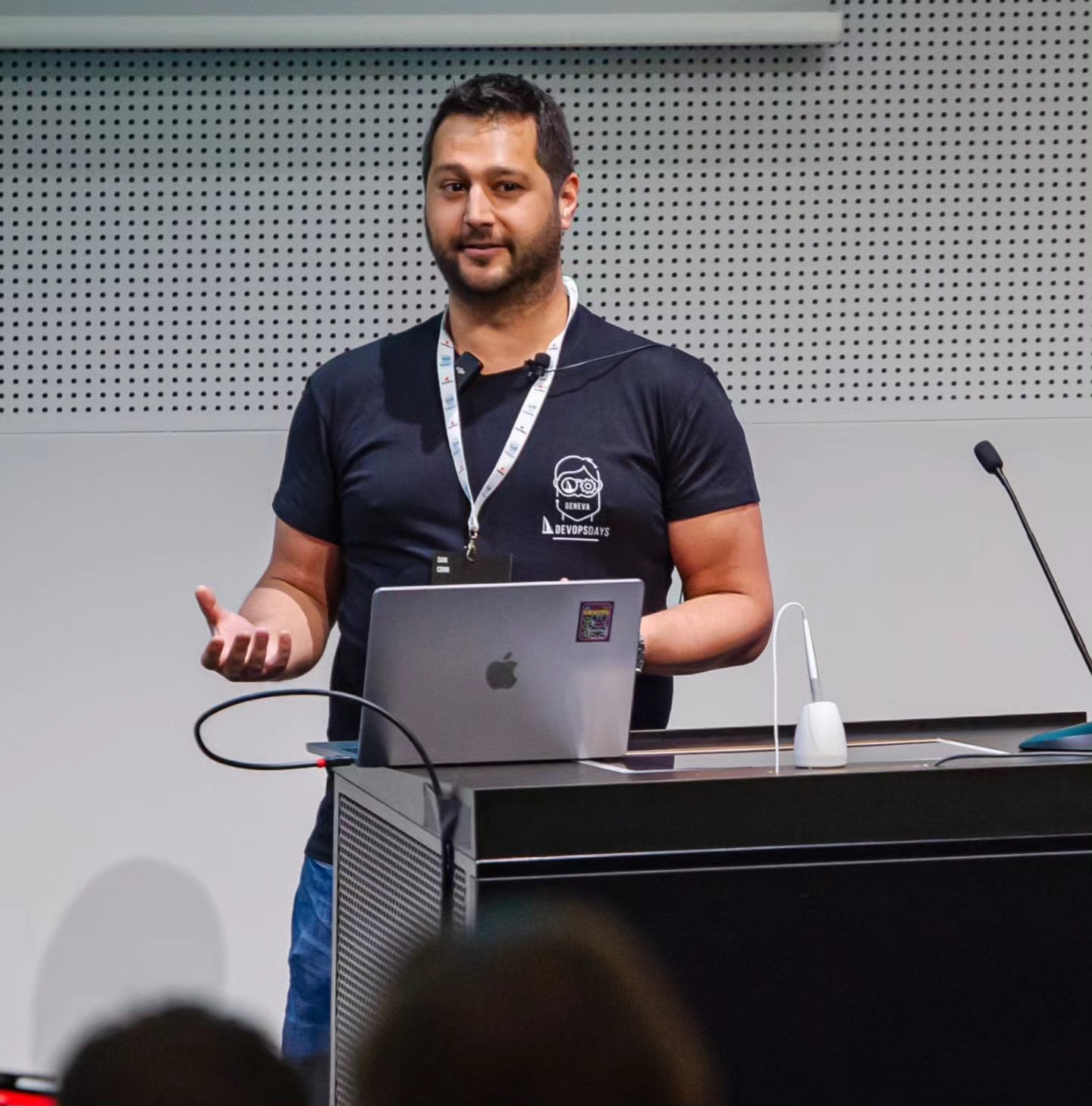 Dan Conn presenting at DevOps Days Geneva, shrugging his shoulders