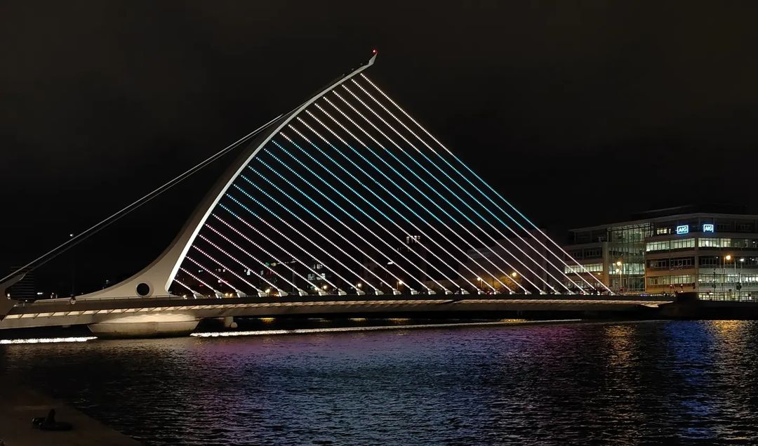 Picture of the bridge on the River Liffey with stands of multicoloured lights adorning it.